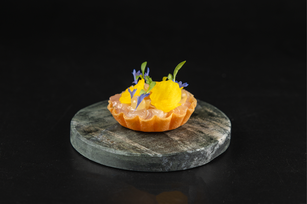 Drapierte Tarte auf Marmorstein, garniert mit Blüten